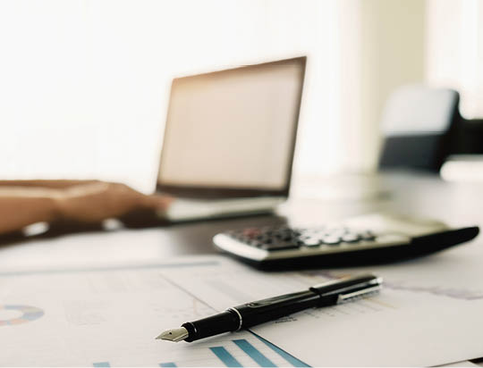 Business concept with copy space  Office desk table with pen focus and analysis chart, computer, notebook, cup of coffee on desk Vintage tone Retro filter, selective focus 