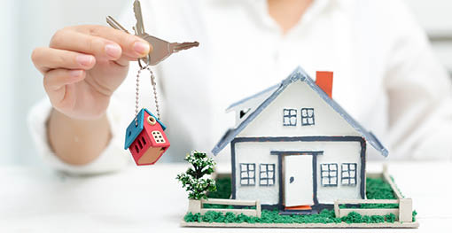 Real estate agent with house model and keys