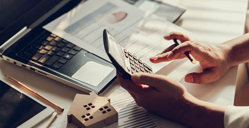 Hand of Business people calculating interest, taxes and profits to invest in real estate and home buying