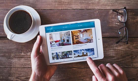 ANZERE, SWITZERLAND - SEPTEMBER 22 2017: Person using Airbnb app to book an apartment online on the screen of smartphone iPhone