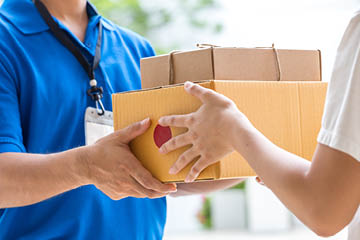 Woman hand accepting a delivery of boxes from deliveryman