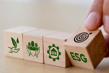 ESG concept of environmental, social and governance  Sustainable corporation development  Hand flips wooden cubes with target setting  to ESG icon with other ESG icons on bright background Copy space 